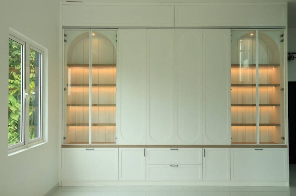 Almari pakaian built-in putih dengan pintu kaca dan rak bercahaya untuk ruang bilik moden